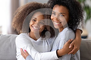 African American mother and daughter hugging, posing for family photo