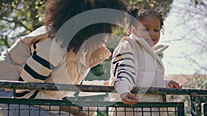 African mother daughter laughing in sunny park closeup. Family relaxing together