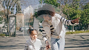 African american mother daughter walking city at sunny holiday. family leisure.