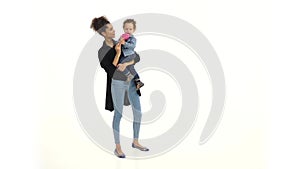 African american mother holds a son, licking a candy and kissing a baby. White background. Slow motion