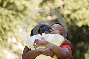 African American mother hugghing her daughter.