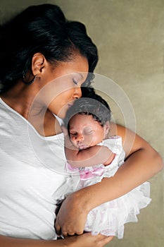 African American Mother Kissing Newborn Daughter