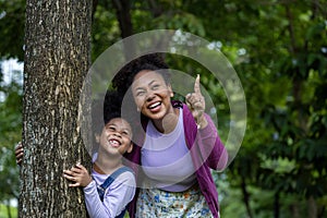 African American mother is playing together with her young daughter while having a summer picnic in the public park for wellbeing