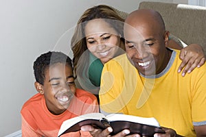 African American multicultural family reading The Bible.