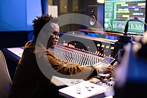 African american music producer composing tracks in control room