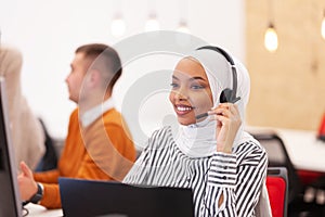 African american muslim girl with hijab and headset in a modern office. Customer service call center