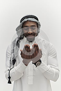 African American Muslim man raises his hands in prayer, seeking solace and devotion to God, as he stands isolated