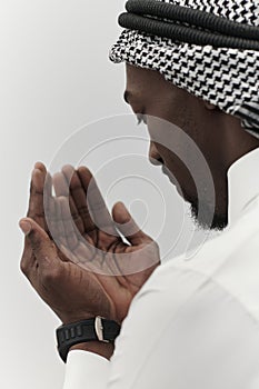African American Muslim man raises his hands in prayer, seeking solace and devotion to God, as he stands isolated