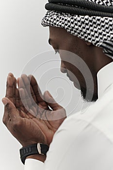 African American Muslim man raises his hands in prayer, seeking solace and devotion to God, as he stands isolated