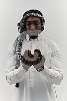 African American Muslim man raises his hands in prayer, seeking solace and devotion to God, as he stands isolated