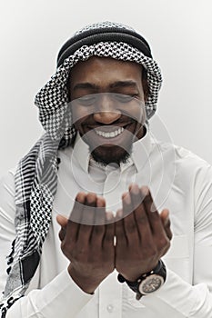 African American Muslim man raises his hands in prayer, seeking solace and devotion to God, as he stands isolated