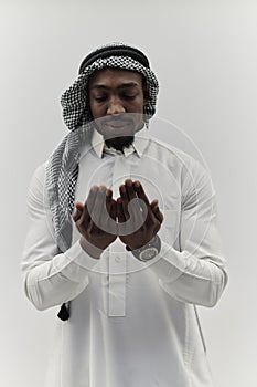 African American Muslim man raises his hands in prayer, seeking solace and devotion to God, as he stands isolated