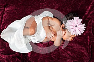 African American Newborn Girl Stirs Slightly In Her Sleep