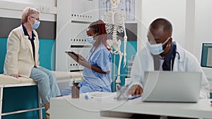 African american nurse consulting senior patient using tablet