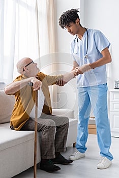 African american nurse helping pensioner with