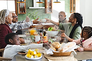 African american parents, children and grandparents celebrating at thanksgiving dinner