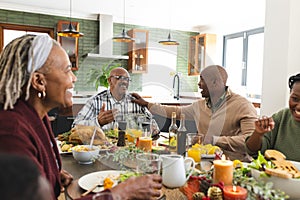 African american parents, children and grandparents celebrating at thanksgiving dinner