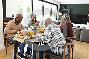 African american parents, children and grandparents celebrating at thanksgiving dinner, slow motion