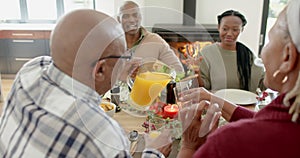 African american parents, children and grandparents celebrating at thanksgiving dinner, slow motion