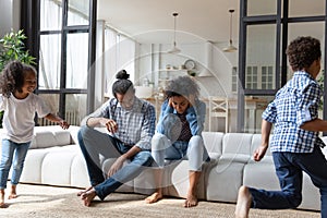 African American parents feeling exhausted, noisy daughter and son running