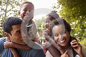 African American parents giving children piggyback rides