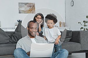 african american parents and son looking at laptop