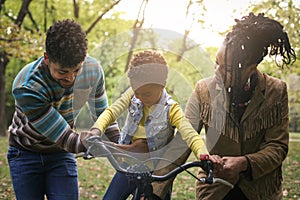 African American parents teaching their little girl to driving b