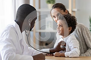 African American pediatrician listening to child lung and heart sound photo