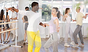 African American performing kizomba with woman in dance studio