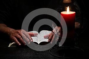 African American Person Studying the Bible in Dark Room photo