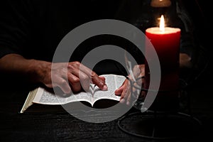 African American Person Studying the Bible in Dark Room photo