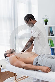 african american physical therapist massaging man