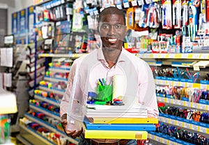 African american male customer choosing paper office supplies in stationery shop photo