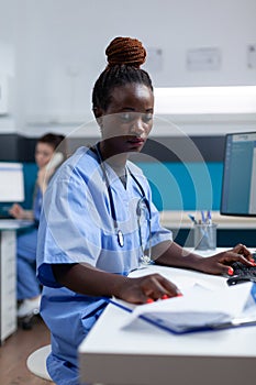 African american practitioner nurse analyzing sickness expertise