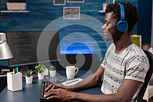 African american programmer with headphones writing program code