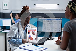 African american radiologist doctor holding tablet explaining heart xray