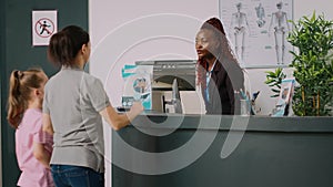 African american receptionist giving assistance to mother and kid