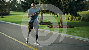 African american runner jogging in park. Sportsman doing cardio workout outdoors