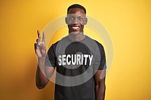 African american safeguard man wearing security uniform over isolated yellow background showing and pointing up with fingers