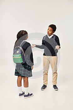 african american schoolkids with backpacks standing