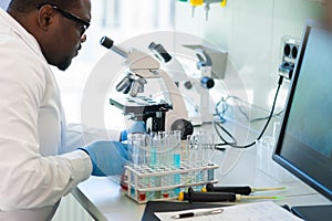 African-american scientist working in lab. Doctor making microbiology research. Laboratory tools: microscope, test tubes