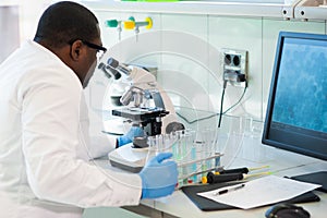 African-american scientist working in lab. Doctor making microbiology research. Laboratory tools: microscope, test tubes