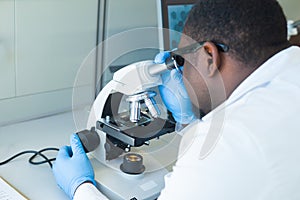 African-american scientist working in lab. Doctor making microbiology research. Laboratory tools: microscope, test tubes