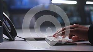 African American security officer types on keyboard, uses landline phone