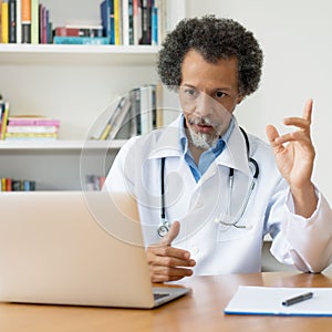 African american senior doctor explaining therapy at video chat
