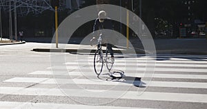 African american senior man riding a bicycle crossing the road