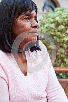 African American senior woman sitting on a bench.