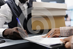 African american shopaholic man signing store receipt