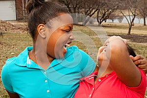 African American sisters and best friends laughing.