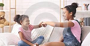 African american sisters giving fist bump to each other at home